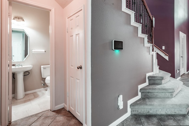 stairs featuring sink and tile patterned flooring