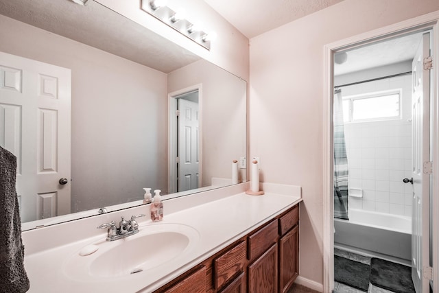 bathroom with vanity, a textured ceiling, and tiled shower / bath combo