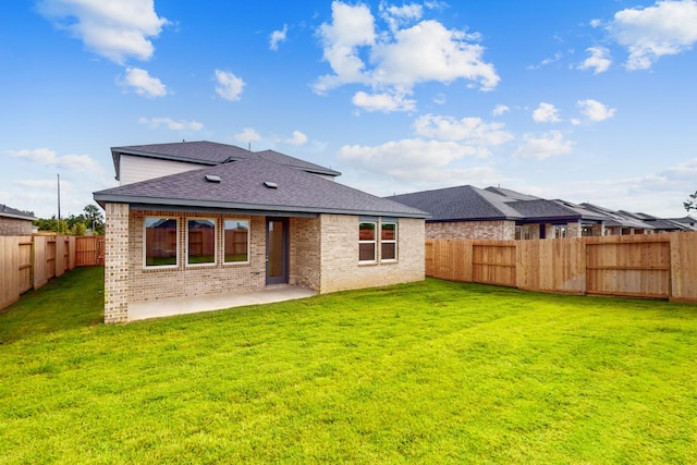 back of property with a yard and a patio