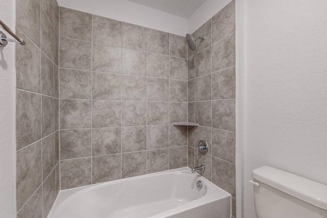 bathroom featuring tiled shower / bath combo and toilet