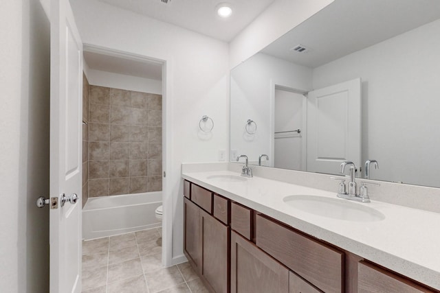 full bathroom featuring tile patterned flooring, vanity, tiled shower / bath combo, and toilet