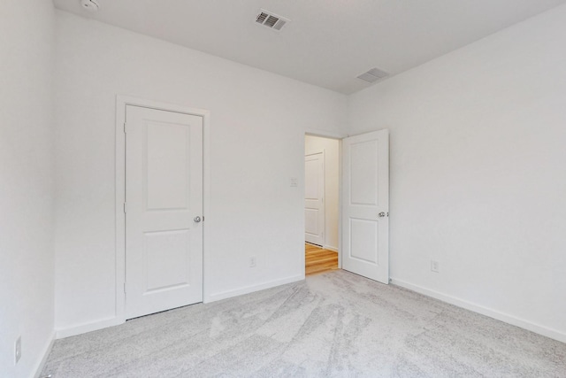 unfurnished bedroom featuring light carpet