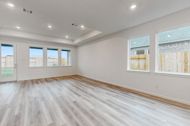 spare room featuring plenty of natural light and light hardwood / wood-style flooring