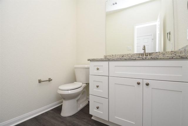 bathroom featuring hardwood / wood-style floors, vanity, and toilet