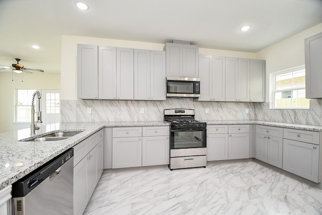 kitchen with a wealth of natural light, ceiling fan, sink, and appliances with stainless steel finishes