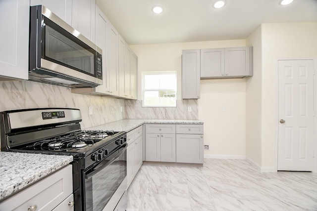 kitchen featuring decorative backsplash, light stone counters, and appliances with stainless steel finishes