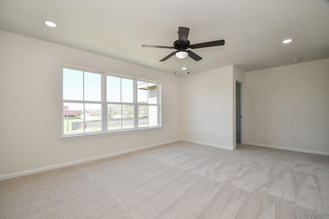 spare room featuring light carpet and ceiling fan