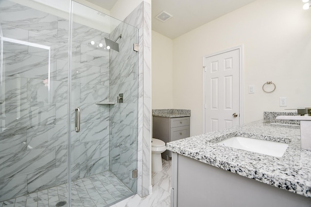 bathroom featuring vanity, a shower with shower door, and toilet