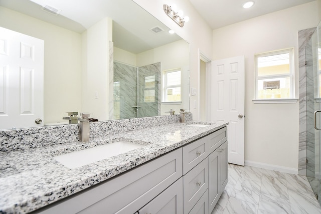 bathroom featuring vanity, a shower with door, and plenty of natural light