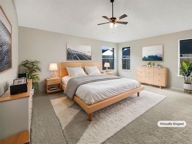 bedroom featuring carpet, ceiling fan, and a textured ceiling