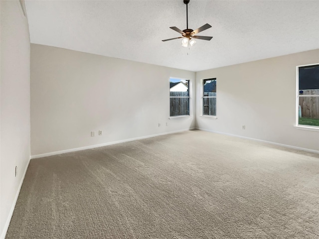 carpeted spare room featuring ceiling fan and a textured ceiling