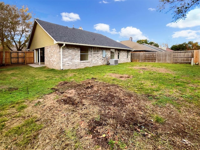 back of property featuring central AC and a lawn