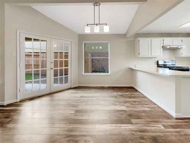 unfurnished dining area featuring french doors, light hardwood / wood-style floors, and vaulted ceiling