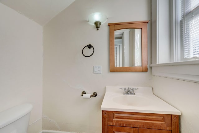 bathroom featuring vanity, vaulted ceiling, and toilet