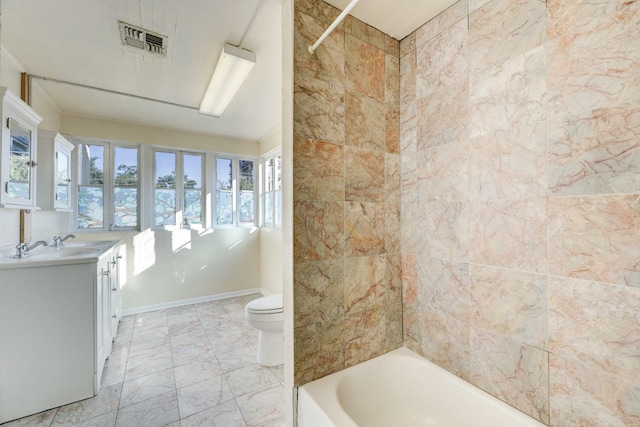 full bathroom with tiled shower / bath, vanity, and toilet