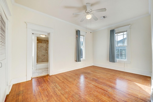 unfurnished room featuring ceiling fan, light wood-type flooring, and ornamental molding