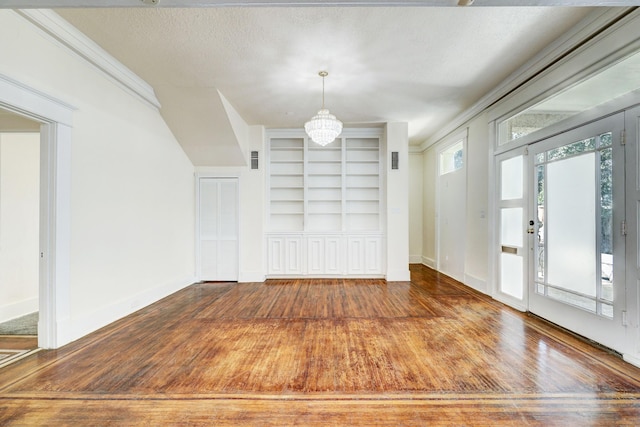 interior space with hardwood / wood-style floors, a textured ceiling, an inviting chandelier, and crown molding