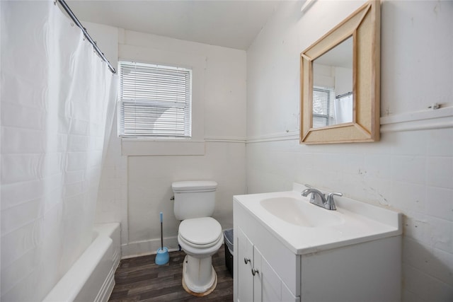 full bathroom featuring hardwood / wood-style floors, vanity, shower / tub combo, and toilet