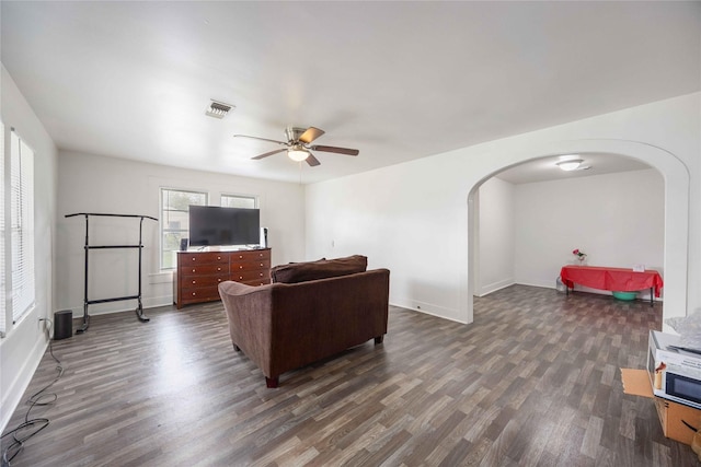 living room featuring ceiling fan and dark wood-type flooring