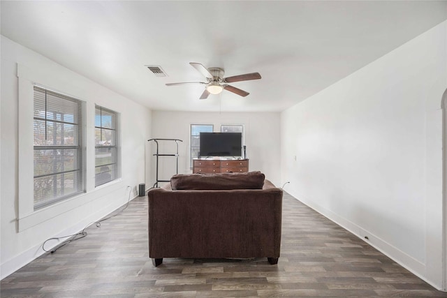 living room with ceiling fan and dark wood-type flooring