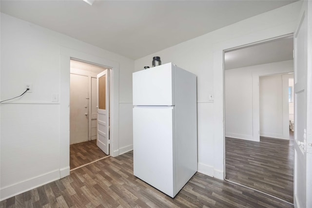 kitchen with white fridge and dark wood-type flooring