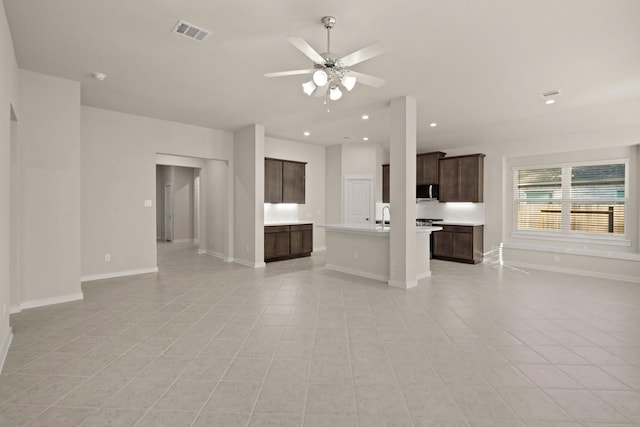 unfurnished living room with light tile patterned floors, ceiling fan, and sink