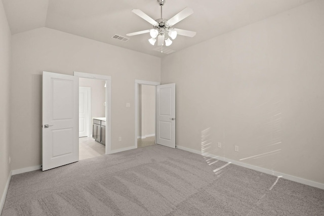 unfurnished bedroom with light colored carpet, vaulted ceiling, and ceiling fan