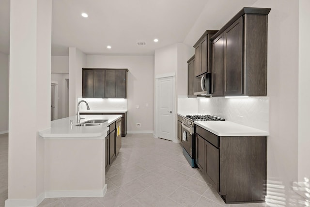 kitchen with backsplash, dark brown cabinets, sink, and stainless steel appliances