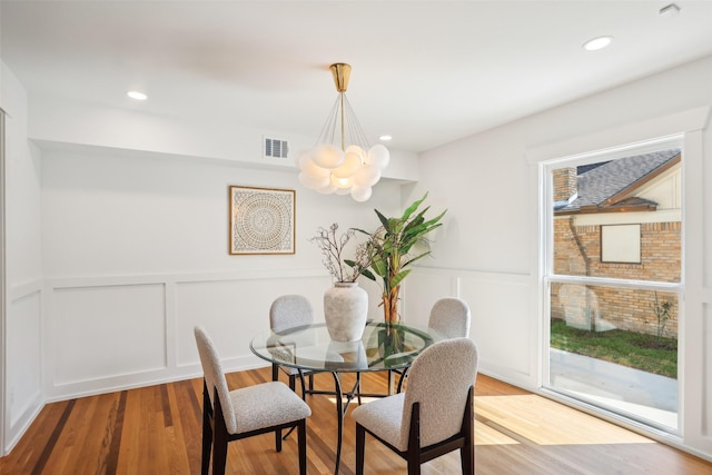 dining space with a notable chandelier and light hardwood / wood-style flooring