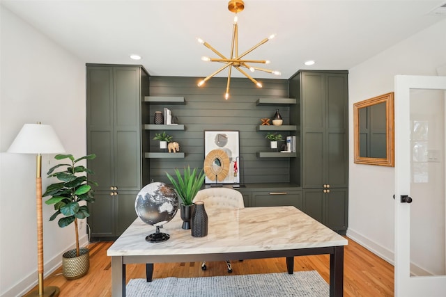 home office featuring light hardwood / wood-style floors and a notable chandelier