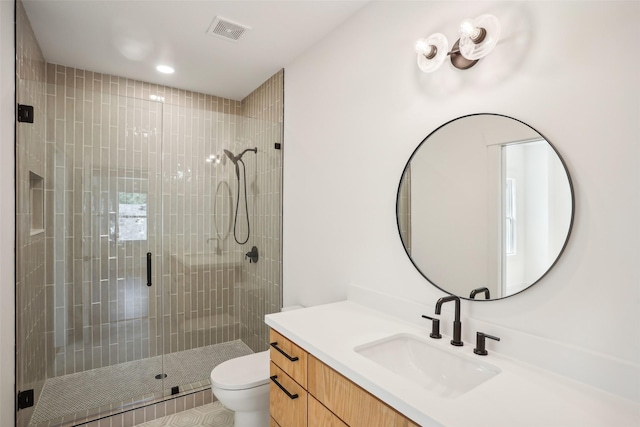 bathroom with tile patterned flooring, vanity, toilet, and a shower with shower door