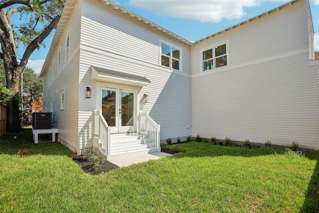 back of property with a lawn and central AC unit