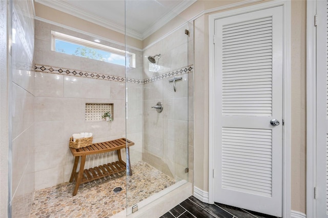 bathroom with crown molding and tiled shower