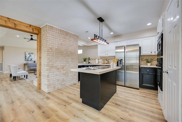 kitchen with decorative backsplash, stainless steel fridge, a center island, and pendant lighting