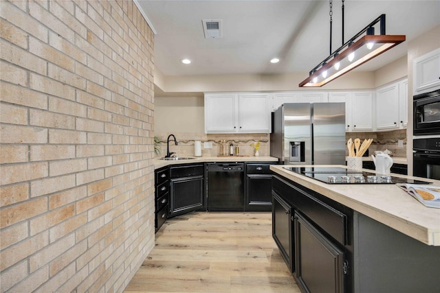 kitchen featuring decorative backsplash, sink, decorative light fixtures, and black appliances