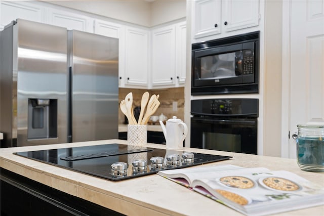 kitchen featuring black appliances and white cabinets