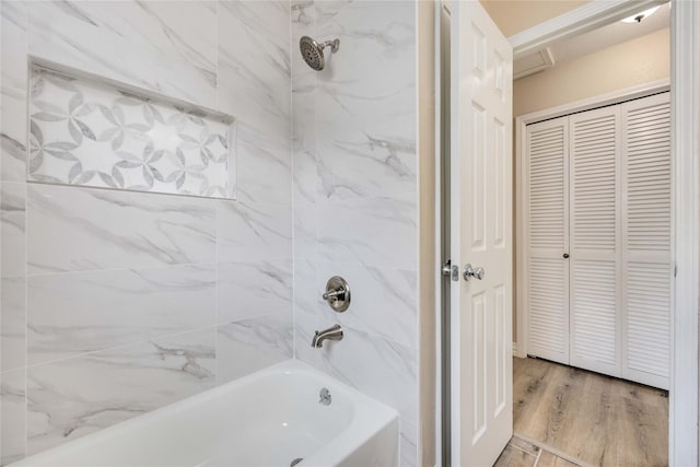 bathroom featuring hardwood / wood-style flooring and tiled shower / bath