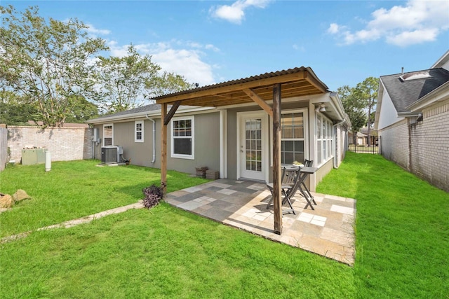 rear view of house with a yard, central AC, and a patio area