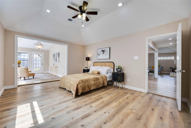 bedroom with light hardwood / wood-style floors, vaulted ceiling, ceiling fan, and a tray ceiling