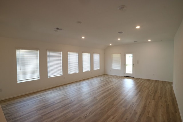 unfurnished room with lofted ceiling and dark wood-type flooring