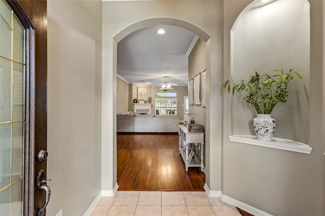 entryway featuring ceiling fan, light hardwood / wood-style floors, and ornamental molding