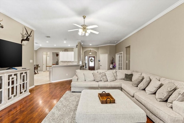 living room with ceiling fan, hardwood / wood-style floors, and ornamental molding