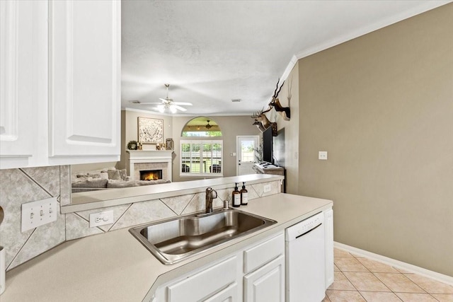 kitchen featuring ceiling fan, sink, white dishwasher, white cabinets, and ornamental molding