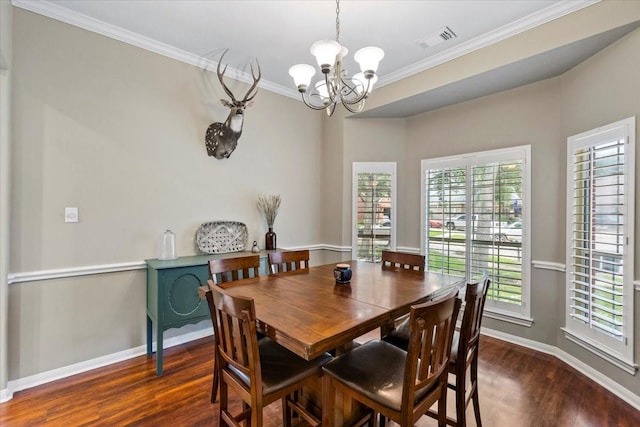 dining space featuring crown molding, dark wood-type flooring, and an inviting chandelier