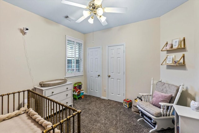 carpeted bedroom featuring ceiling fan and a nursery area