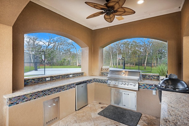 view of patio / terrace with grilling area, ceiling fan, and an outdoor kitchen