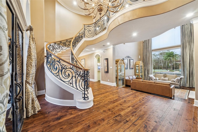 entryway featuring ornamental molding, a high ceiling, and hardwood / wood-style flooring