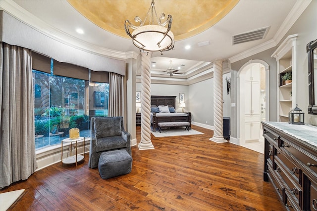 sitting room with hardwood / wood-style floors, ornate columns, built in features, and a tray ceiling