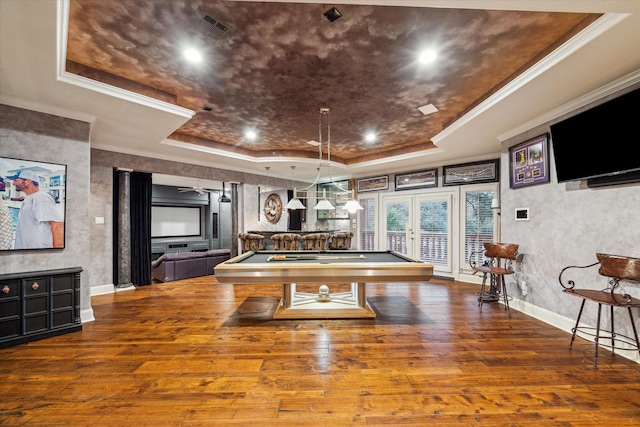 recreation room with a tray ceiling, wood-type flooring, ornamental molding, and billiards