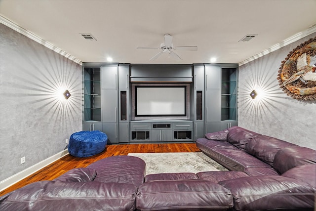 home theater featuring dark hardwood / wood-style flooring, ceiling fan, and crown molding